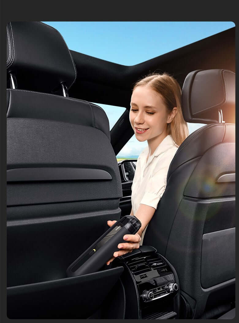 Woman using portable wireless car vacuum cleaner in the back seat of a car, showcasing compact design and ease of use.